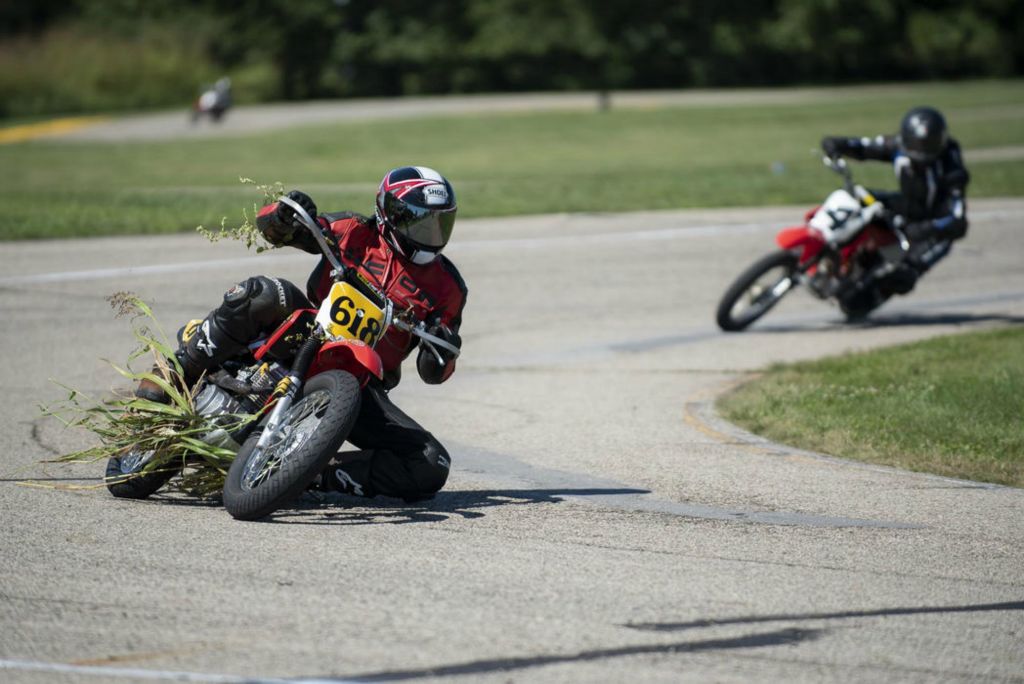 First Place - Larry Fullerton Photojournalism Scholarship , Tanner Pearson / Ohio UniversityDan Thatcher rides his motorcycle with shrubs hanging from it at the Circleville Raceway Park on Sept. 5, 2020. Thatcher had gone off the track and into shrubbery that continued along the track with him. The race was momentarily paused so the grass could be removed to continue the race safely.