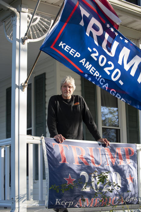 First Place - Larry Fullerton Photojournalism Scholarship , Tanner Pearson / Ohio UniversityTim Henderson, 64 of Kettering poses on his front porch with his Trump flags in Lytle, Ohio on Sept. 20, 2020. While having multiple Trump signs now, Trump wasn’t Henderson’s first choice as a president back in 2016. Henderson didn’t want the opposition to win, so he voted for Trump. “As I’ve watched him (Trump) and some of the things that he has done, he has been true to his word, so I’ve become very fond of him. Do I like everything he says? No. But that is alright. He is not my pastor in chief, he’s the commander in chief. So, I’ve been able to separate that.” 