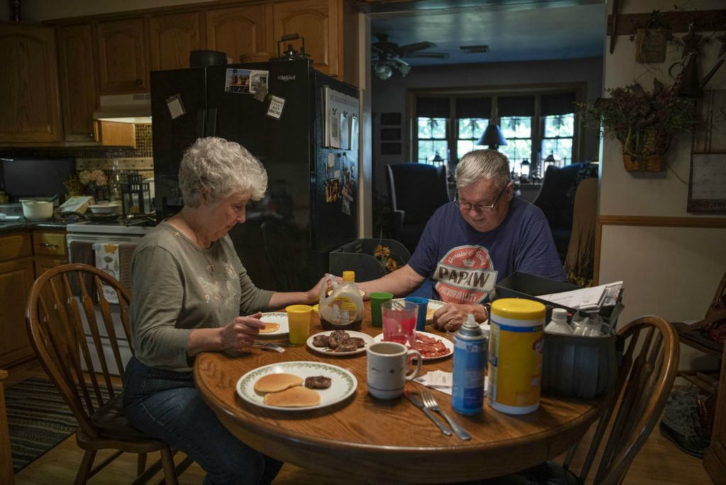 Second Place - Larry Fullerton Photojournalism Scholarship , Grace Wilson / Ohio UniversityMike and Karen pray at breakfast on Oct. 16, 2020. Prayer is a centerfold in both of their lives. A clock in the kitchen plays Amazing Grace every hour as a reminder to always give thanks to God.