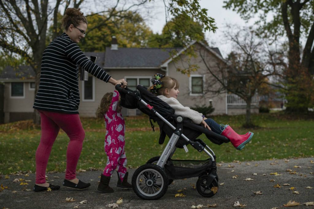 Second Place - Larry Fullerton Photojournalism Scholarship , Grace Wilson / Ohio UniversityCait Denny walks to the bus stop with her children, Abigail (left), and Caroline (right). She tries to keep her children sheltered from this virus, and says, "My kids never showed any signs of being afraid of Corona, but the lockdown still impacted them greatly...My social butterfly preschooler cried over missing her friends or the slightest inconvenience...My middle daughter who had been potty trained for a year regressed so completely that I had to put her in pull-ups and start potty training from scratch."