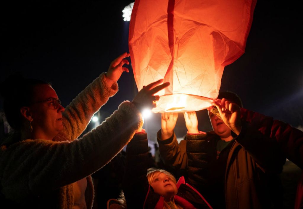 First Place - Larry Fullerton Photojournalism Scholarship -  Brandiss, Scarlett, and Easton send a Chinese lantern into the night sky after the celebration of life for six-year-old James Hutchinson at Barnitz Stadium in Middletown, Ohio, on March 2, 2021. Brandiss and her family are members of the Rylee Sellars Foundation, a non-profit that was created to advocate on behalf of children that are abused and neglected, and came to the celebration of life to honor James’ memory. (Joe Timmerman - Ohio University)  
