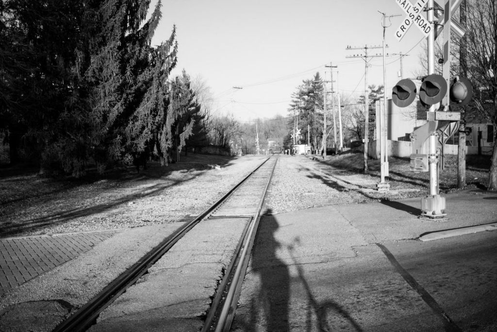 First Place - Larry Fullerton Photojournalism Scholarship -  My shadow crosses the railroad tracks that run through my hometown of Loveland, Ohio, as I ride my bike home from my restaurant job on January 9, 2021. While living back at my parents’ house, I would cross these tracks every day to and from work, sometimes thinking about the freedom the trains have that pass through. (Joe Timmerman - Ohio University)  