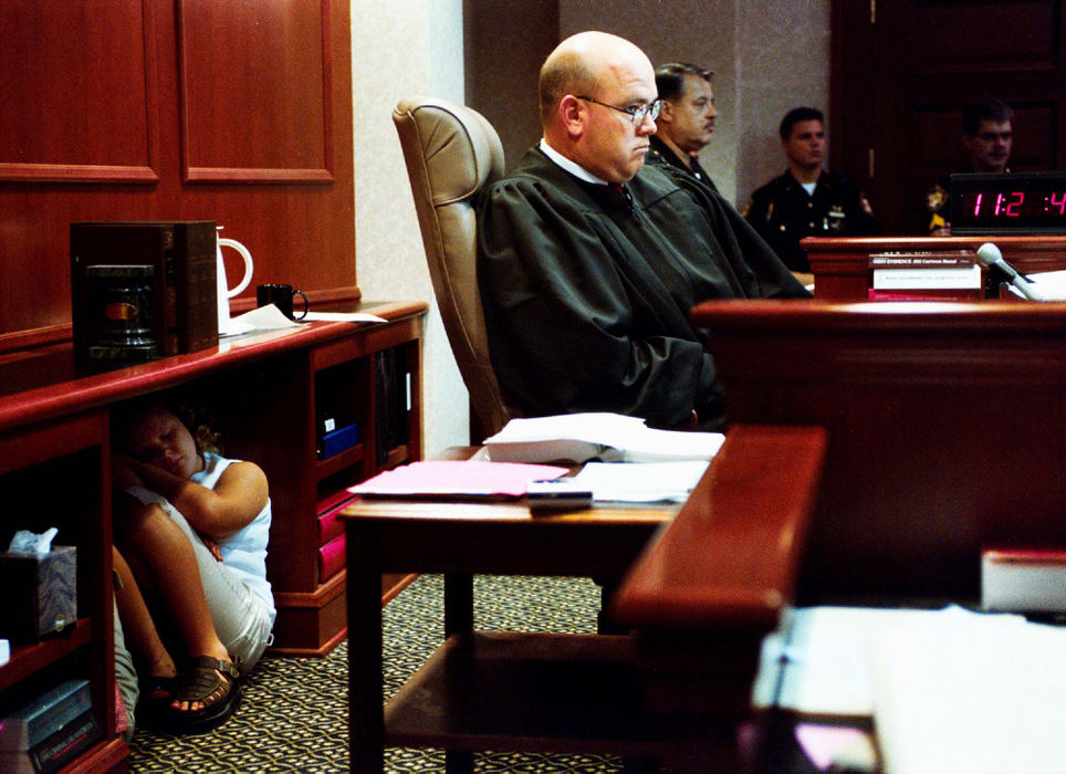 Second Place, Assigned Feature - Greg Lynch / Hamilton Journal-NewsAbby Spaeth crouches under a desk to get a new perspective on her father's job. Butler County Common Pleas Court Judge Kieth Spaeth brought  Abby and her friend Abby Snyder (hidden) to court for an early bring your daughter to work day.