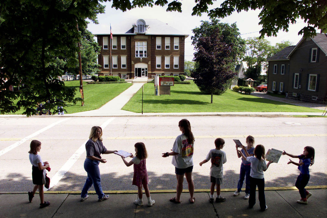 Third Place, Assigned Feature - Chris Russell / The Columbus DispatchChildren and teachers from Thornville Elementary School make a human chain to move books from the old library to the new library. 