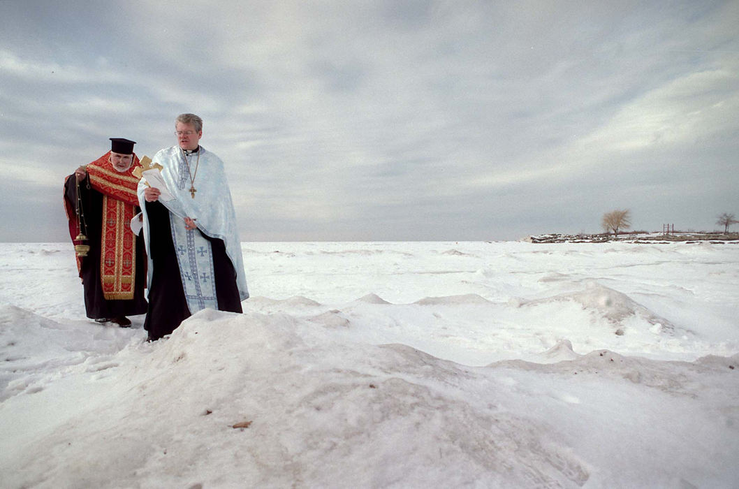 Award of Excellence, Assigned Feature - Dale Omori / The Plain DealerRev. Fr. Vladimir Ivanov and Abbot Fr. John Henry from St. Herman of Alaska Monastery and House of Hospitality walks across the frozen beach at Cleveland's Edgewater Park during the annual Great Blessing of the Waters ceremony.