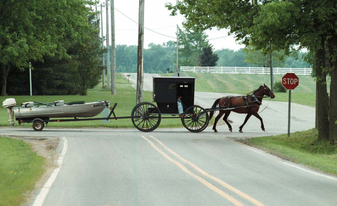 Award of Excellence, Assigned Feature - Lisa Dutton / The BladeAn Amish horse and buggy pulls a motorized fishing boat behind it in Shipshewana, Indiana.