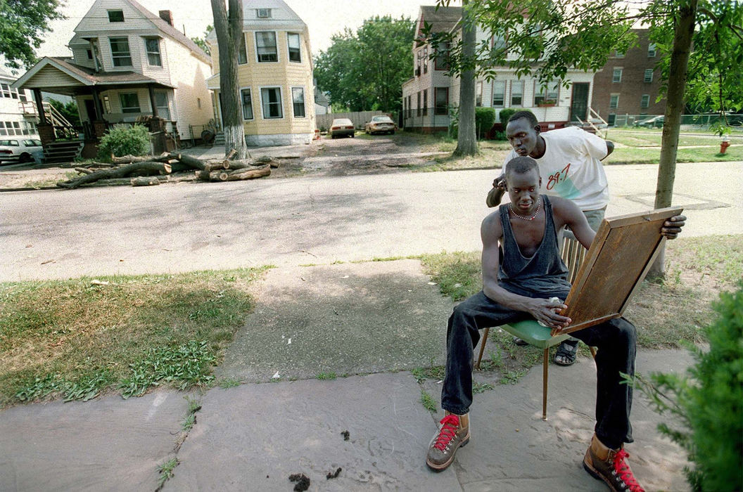 Award of Excellence, Feature Picture Story - Lynn Ischay / The Plain DealerAppearance is important to the Sudanese men. Dominic Mel cuts Akol Akol's hair outside their temporary home in Father Albert House in Cleveland's Hough neighborhood. 