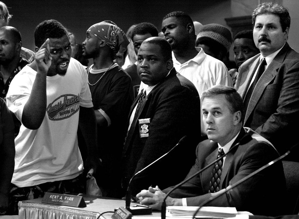 Third Place, General News - Steven M. Herppich / Cincinnati EnquirerA City Divided-Almost two hundred protestors crowd around city council members as an angry Ronnie Stallworth yells at Cincinnati Police Chief Tom Streicher during a hearing of the law committee at City Hall in Cincinnati following the killing of Timothy Thomas, an unarmed African American, by police officer Stephen Roach two days earlier. The shooting lead to one week of protests, riots, and an city imposed curfew leading up to the funeral of this 19-year-old man.