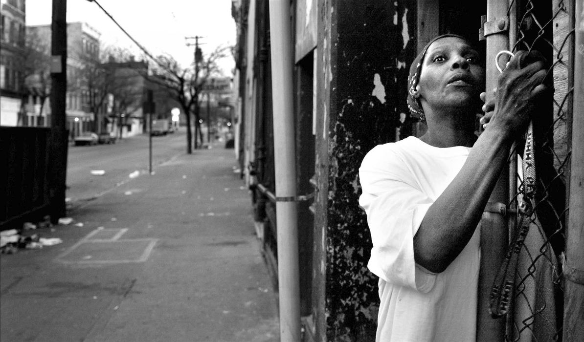 First Place, News Picture Story - Steven M. Herppich / Cincinnati EnquirerAn unidentified woman watches from her doorway as police arrest a group of young men on Elder and Elm Street at 8:15 pm after a sity imposed curfew started Thursday night April 12, 200. The city was placed on a state of emergency following two days of rioting after Timothy Thomas was shot by a police officer earlier in the week.