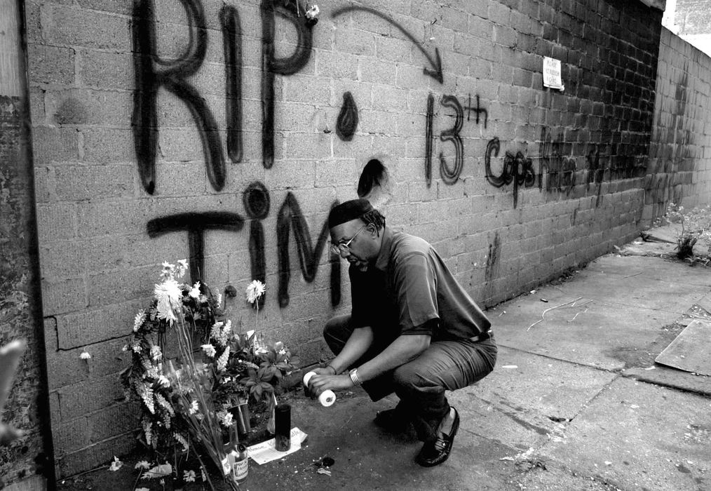 Second Place, News Picture Story - Michael E. Keating / Cincinnati EnquirerIn the quiet before the storm, an acquaintance of Timothy Thomas lights a candle at a makeshift memorial.  Thomas was the 13th African-American male killed during contact with Cincinnati Police in recent years.  An unarmed Thomas was shot in this spot while being pursude by police for outstanding warrants.  Protestors took to the streets in the following days resulting in civil unrest.