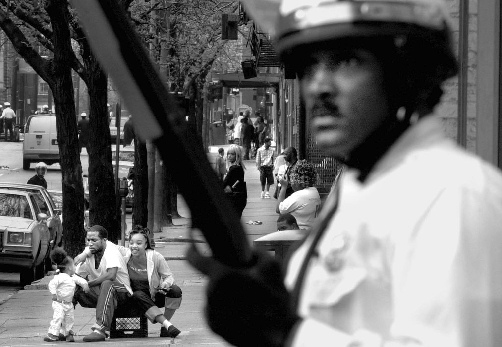 Second Place, News Picture Story - Michael E. Keating / Michael E. KeatingWith police in riot gear in place to keep the calm a mother, father and young daughter take up a curbside vantage point to watch the action unfold. Police presence on the streets is commonplace.