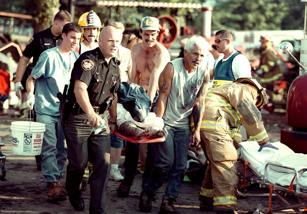 Third Place, News Picture Story - Shirley Ware / The Medina GazettePolice and civilians work side by side to help vitims of the Sunday evening explosion at the Medina County Fair. A antique steam tractor exploded Sunday evening July 29th, 2001, just after it arrived at the fair grounds.  Four people were killed, and 49 were injured by shrapnel, steam and boiling water including 2 police officers and numerous children.