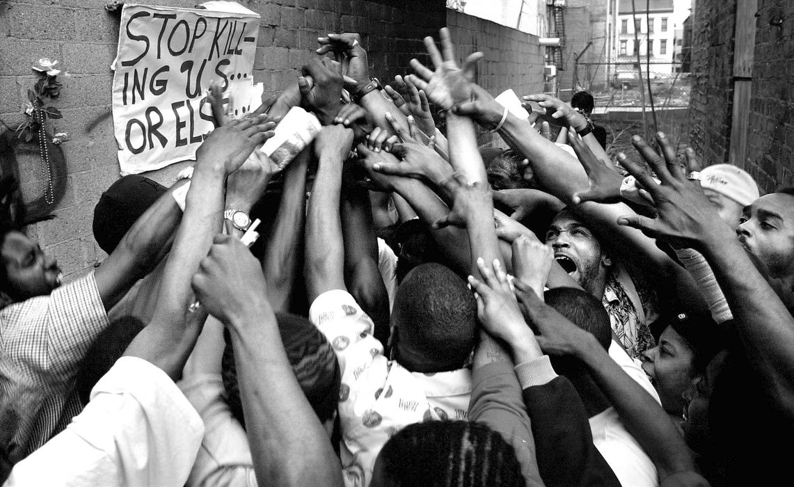 First Place, News Picture Story - Steven M. Herppich / Cincinnati EnquirerProtestors gather at the scene of the fatal police shooting of Timothy Thomas where a  memorial has been place in the alleyway by Republic Street in Over-the-Rhine. Thomas was shot and killed by a Cincinnati Police officer Saturday April 7, 2001. The shooting lead to one week of protests, riots, and a city imposed curfew leading up to the funeral of this 19-year-old man.