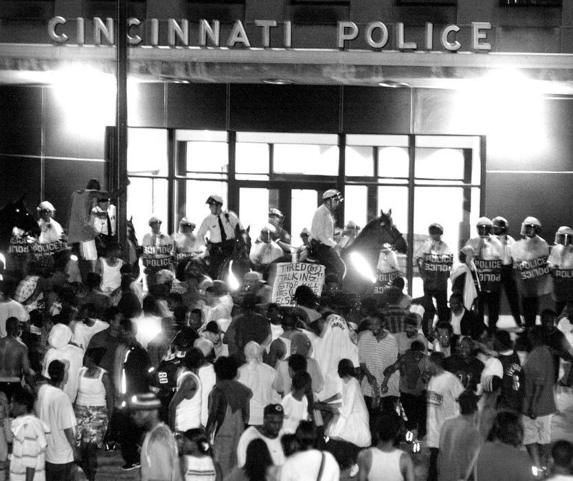 First Place, News Picture Story - Steven M. Herppich / Cincinnati EnquirerCincinnati Police in riot gear and on horses move a crowd of protesters away from the main entrance to Cincinnati Police headquarters on Ezzard Charles Drive Monday, April 9, 2001. The crowds had moved thru OTR following a tense meeting at City Hall about the police shooting of Timothy Thomas Saturday,April 7,2001. 