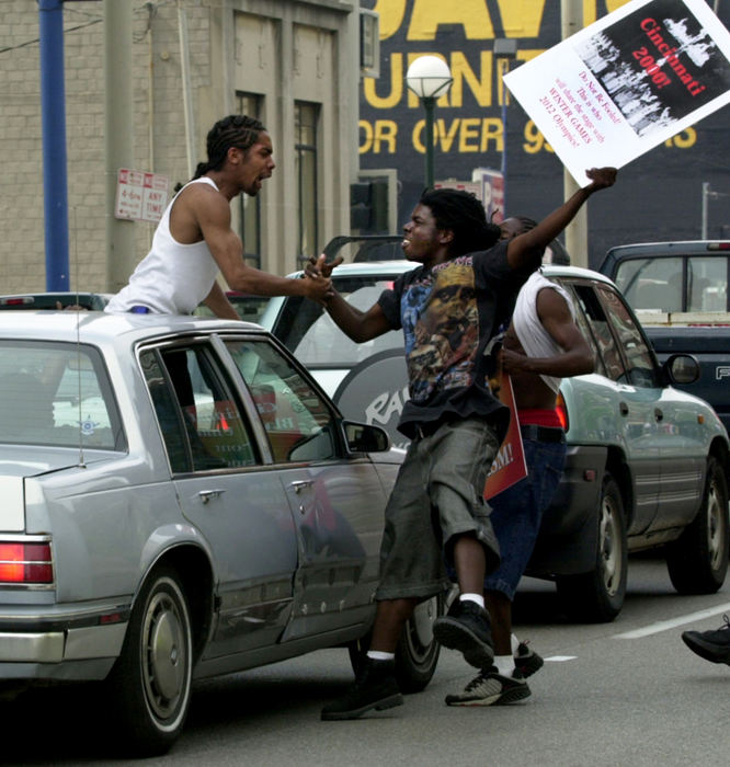 Award of Excellence, News Picture Story - Brandi Stafford / The Cincinnati EnquirerProtestors fill the streets outside Hamilton County Courthouse in anticipation of the Grand Jury findings of Cincinnati Police Officer Stephen Roach's shooting death of Timothy Thomas. The shooting death of an unarmed black man by a police officer sparked days of rioting. 