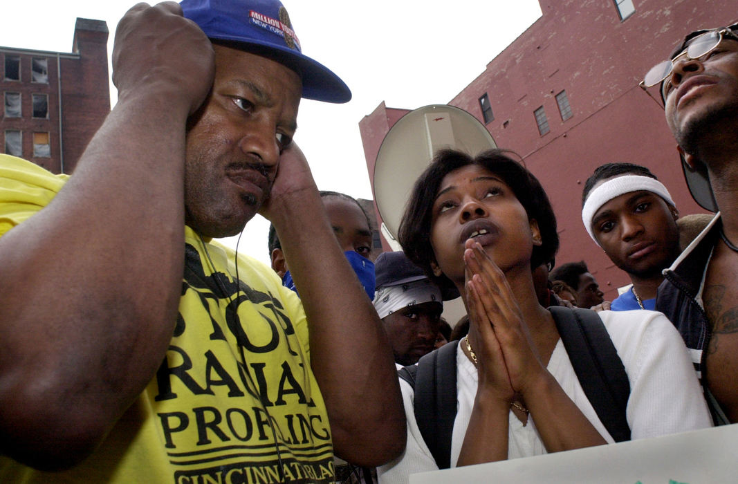 Award of Excellence, News Picture Story - Brandi Stafford / The Cincinnati EnquirerPamela Williams looks up and prays as General Kabaka Oba listens to the radio using headphones to hear the Grand Jury findings of Cincinnati Police Officer Stephen Roach's shooting death of Timothy Thomas. 