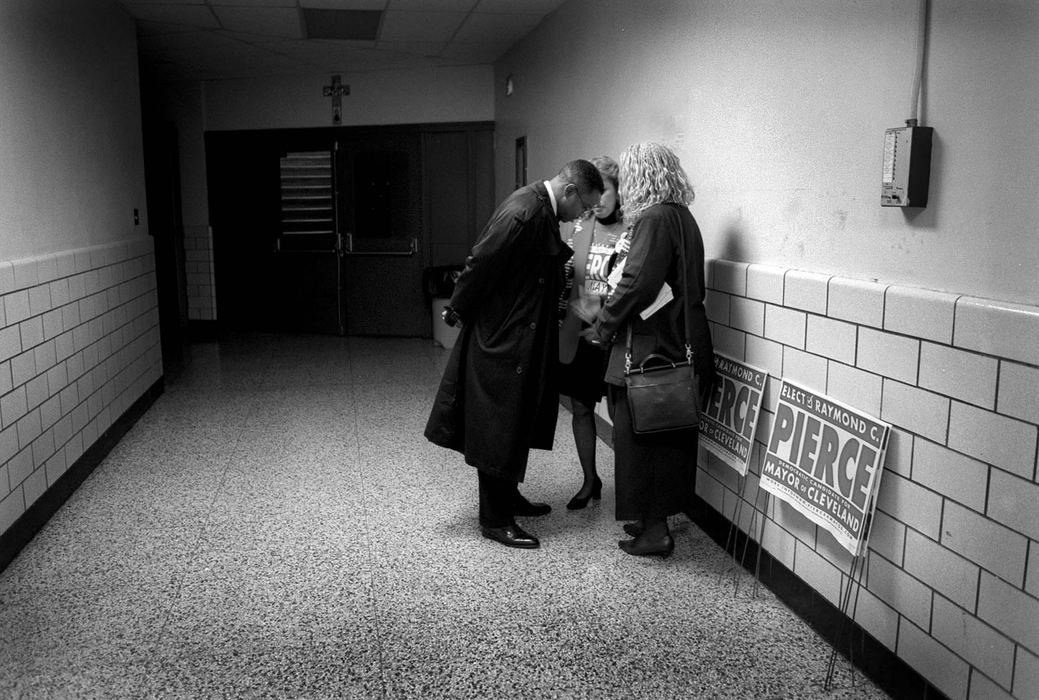 Award of Excellence, News Picture Story - Dale Omori / The Plain DealerCleveland mayoral candidate Raymond Pierce huddles with Team Pierce, Diana Trego and Keli Garrett after a meeting of the Ward 18 Democrats at St. Ignatius Church on Cleveland's West Side.  Team Pierce is his advance team, setting up signs, etc., before each campaign stop. 