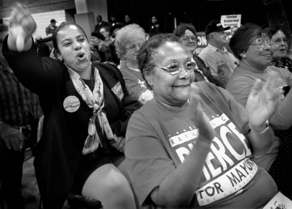 Award of Excellence, News Picture Story - Dale Omori / The Plain DealerDelina Macon, a volunteer in the mayoral campaign of Jane Campbell gives a thumbs-down to candidate Raymond Pierce during his closing statement.  Pierce supporter and campaign worker, Gloria Sallee-Rice applauds at Candidate's Night sponsored by the Cleveland Neighborhood Development Corporation at OLA/St. Joseph Center.