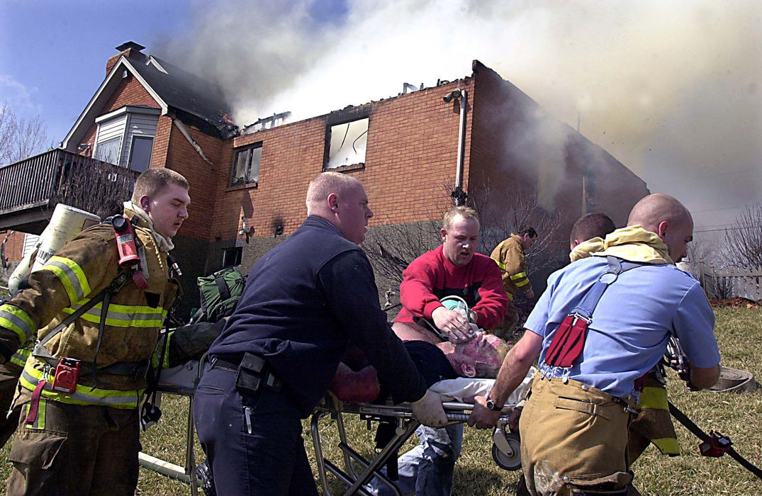 Award of Excellence, News Picture Story - Glenn Hartong / The Cincinnati EnquirerMiami Twp firefighter/paramedic Bill Ellison is rushed to the University Aircare helicopter after falling from the first floor into the basement of a house during a three-alarm fire on Jordan Road in Miami Township. He is at University Hospital in critical condition. 