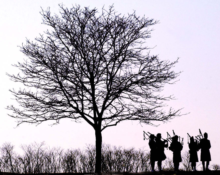 Award of Excellence, News Picture Story - Glenn Hartong / The Cincinnati EnquirerAs they play "Amazing Grace" bagpipers are silhouetted against the sky next to a lone tree during firefighter/paramedic William "Doc" Ellison's burial at St. Stephen Cemetery in Fort Thomas Kentucky.