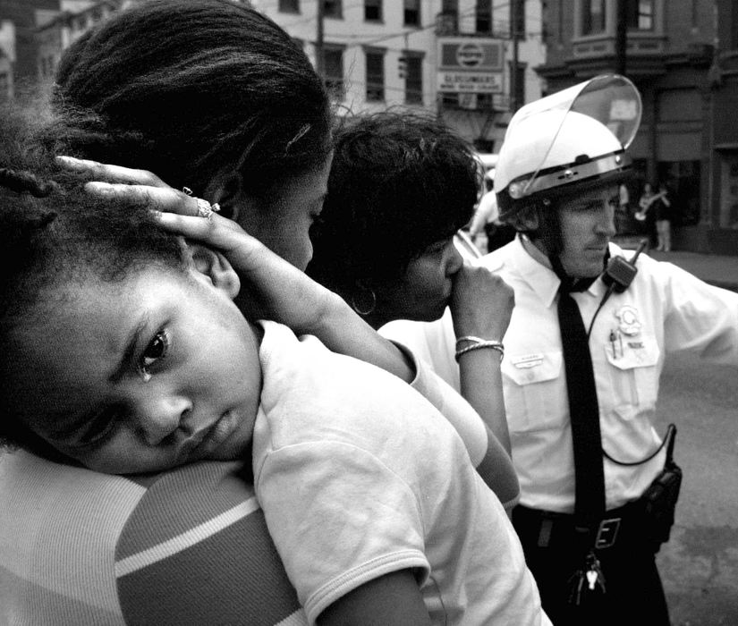 First Place, News Picture Story - Steven M. Herppich / Cincinnati EnquirerTiffany McCants, of Over-the-Rhine, holds her daughter, DarRiell, 3, after the two were hit from behind on the corner of 12th and Vine St. Wednesday afternoon during rioting related to the police shooting of Timothy Thomas. A Cincinnati Police Officer said the car that hit her was struck by a projectile as it was coming up Vine Street and swerved into Ms. McCant's car. 