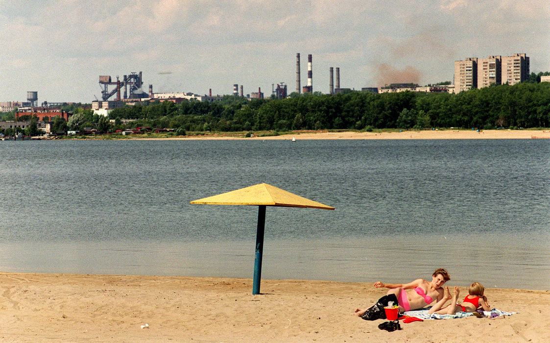 First Place, Ohio Understanding Award - Mike Levy / The Plain DealerSunbathers enjoy the afternoon at a beach across from Severastal's steel mill. The company spent next to nothing on environmental controls until a decade ago. "The... water taken from the river was thrown back dirty," says Nikolay Arkhipov, who heads Severstal's nature management division. "Today we are able to clean 98 percent of the water we use."