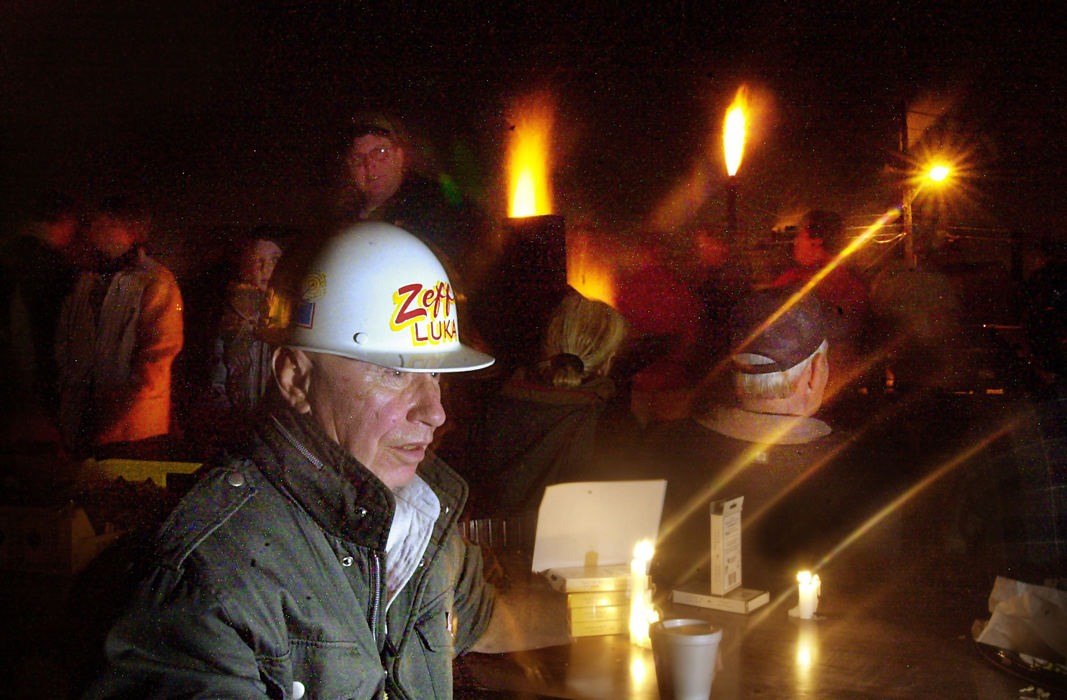 First Place, Ohio Understanding Award - Mike Levy / The Plain Dealer Zef Luka, 76, of Cleveland, quietly sits at a table where he lit a candle at last night's vigil in front of LTV's building at Broadway and E. 51st St. Luka, an LTV retiree, worked in the mill for 37 years - his only job since coming to America from Albania almost 50 years ago.