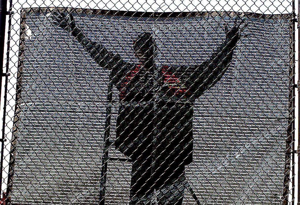 First Place, Pictorial - Bill Lackey / Springfield News-SunA worker is silhouetted in the sunshine against a wind screen he was hanging up around the tennis courts at Wittenberg University Wednesday. The worker was one of several young people from the Clark County Juvenile Courts who were working on the tennis courts as part of their community service for the courts. 