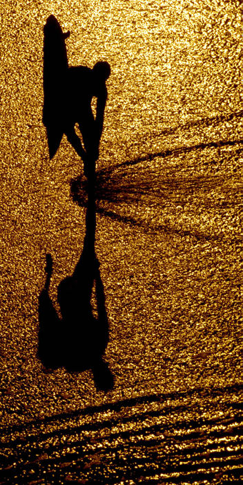 Award of Excellence, Pictorial - Bill Reinke / Dayton Daily NewsThe early morning light spills onto Huntington Beach, California, as a surfer checks the temperature of the water. The waves were just right and there were many surfers taking advantage of the balmy weather and good waves.