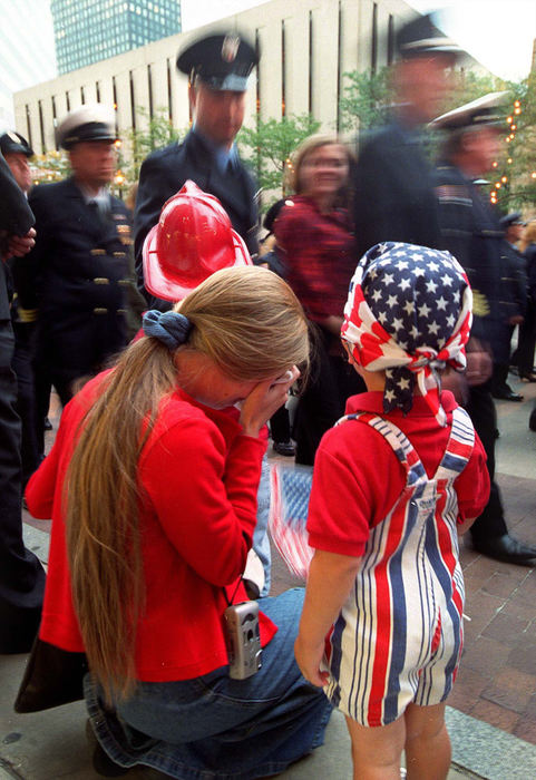 First Place, Photographer of the Year - Mike Levy / The Plain DealerA mother weeps with her children as a procession of fire fighters and police officer make their way down E. Ninth Street for a memorial service for those that lost lives 9/11.