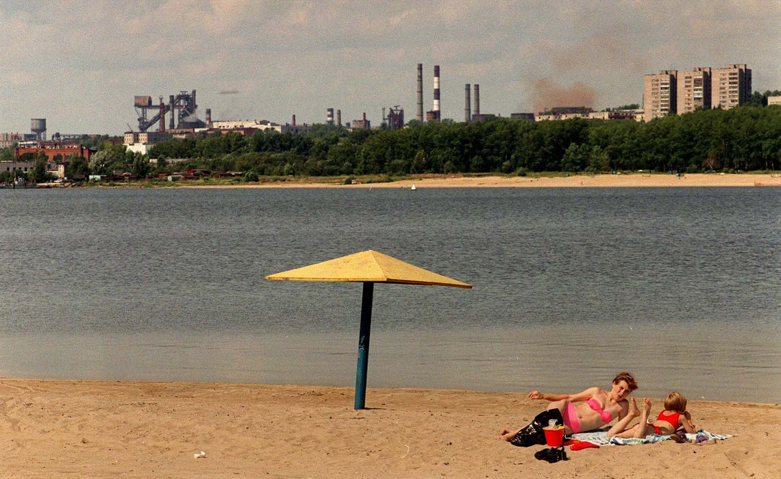 First Place, Photographer of the Year - Mike Levy / The Plain DealerWith Cleveland's LTV steel going under many wondered what other countries were  doing to survive the hard economic times for steel manufacturing.  Russian steel was indicted  by the US for dumping steel in this country. This group of photos, taken in Cherepovets, Russia examines and compares the realities of  US steel versus Russian steel.   On the banks of a river that was once black because of pollutants from the steel mill a mother and daughter bask in the warm afternoon sun with Severstal steel dotting the landscape.