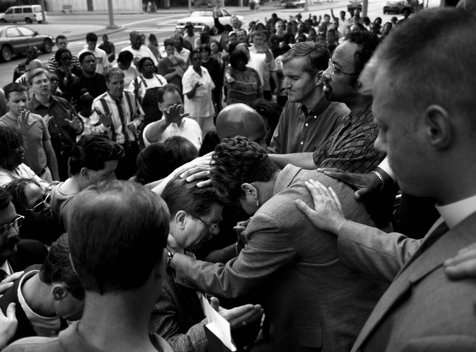 Second Place, Photographer of the Year - Steven M. Herppich / Cincinnati EnquirerArea ministers lay hands on city workers and officials as they pray together along with hundreds of people on the steps of City Hall, May 3, 2001 as part of National Prayer Day. Area ministers lead the group in prayer to end the strife in Cincinnati after weeks of protests and riots following the shooting death of a young black man by a Cincinnati police officer. 