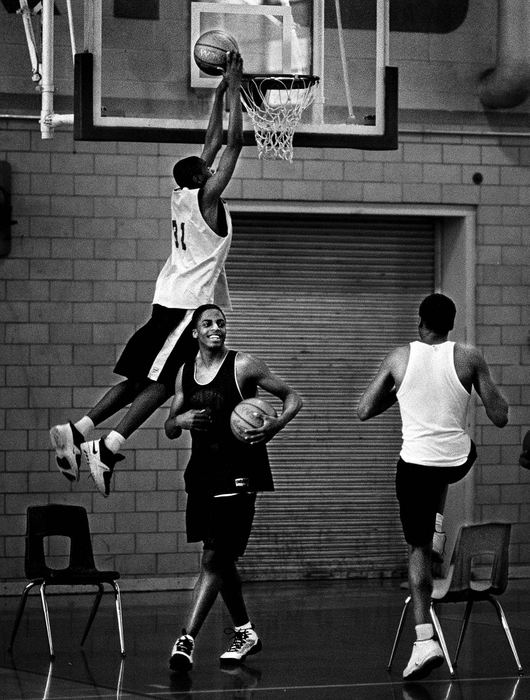 Second Place, Photographer of the Year - Steven M. Herppich / Cincinnati EnquirerChair men of the Boards-Eugene Thomas, 16, gets a basketball for another try as his teammate Shawn Bishop tries to dunk the ball with the aid of a chair before JV basketball practice starts after school at Robert A. Taft High School. 