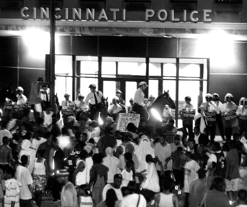 Second Place, Photographer of the Year - Steven M. Herppich / Cincinnati EnquirerCincinnati Police in riot gear and on horses move a crowd of protesters away from the main entrance to Cincinnati Police headquarters on Ezzard Charles Drive, April 9, 2001. The crowds had moved thru OTR following a tense meeting at City Hall about the police shooting of Timothy Thomas, April 7,2001. 