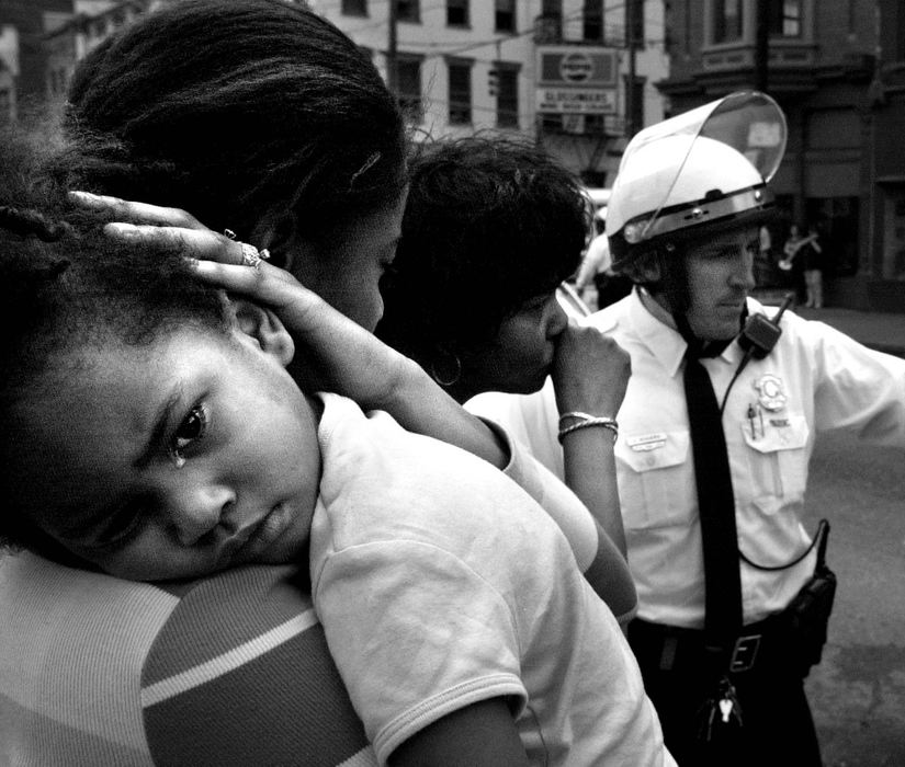 Second Place, Photographer of the Year - Steven M. Herppich / Cincinnati EnquirerTiffany McCants, of Over-the-Rhine, holds her daughter, DarRiell, 3, after the two were hit from behind on the corner of 12th and Vine St. during rioting related to the police shooting of Timothy Thomas. A Cincinnati Police Officer said the car that hit her was struck by a projectile as it was coming up Vine Street and swerved into Ms. McCant's car. 