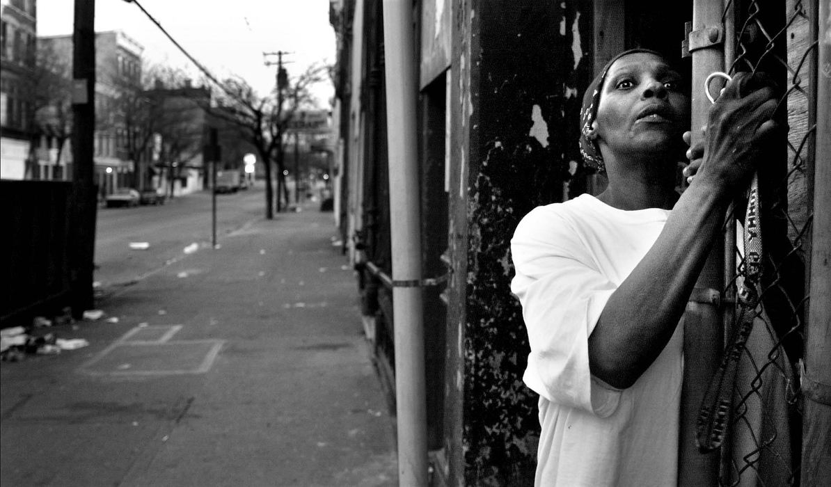 Second Place, Photographer of the Year - Steven M. Herppich / Cincinnati EnquirerAn unidentified woman watches from her doorway as police arrest a group of young men on Elder and Elm Street at 8:15 pm after a city imposed curfew started April 12, 2000. The city was placed on a state of emergency following two days of rioting after Timothy Thomas was shot by a police officer earlier in the week.