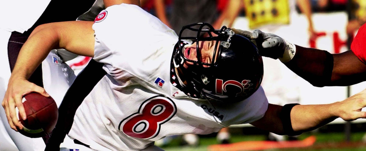 Award of Excellence, Sports Action - Ernest Coleman / The Cincinnati EnquirerUniversity of Cincinnati's Gino Guidugli almost looses his helmet as his is stacked for loss in the third quarter of play against Miami of Ohio. There was no flag on the play.