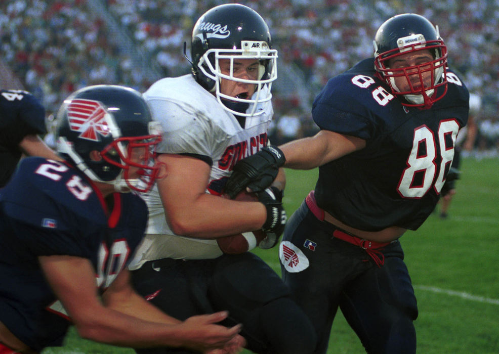 First Place, Student Photographer of the Year - David Distelhorst / Ohio UniversityGrove City junior Josh Goody pulls in the ball in the end zone while Piqua defenders Derrick Fry (right) and Brad Valentine attempt to stop him during the second quarter, August 25, 2001.