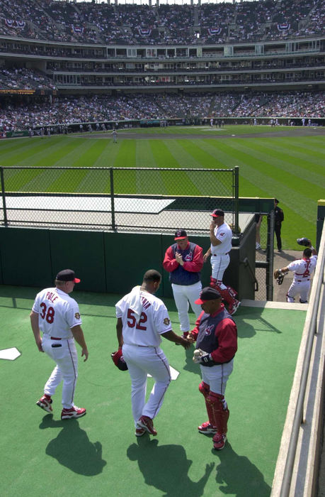 Second Place, Sports Picture Story - Chuck Crow / The Plain DealerFrom one great Indians pitcher to the next, a promising Cleveland Indian season included  sensational rookie pitcher C.C. Sabathia, walking out of the pitchers bullpen for his first professional start at Jacobs Field in April. Shaking his hand is bullpen coach Luis Isaac. Sabathia ended up in 2nd place in rookie of the year competition behind Ichiro of Seattle.