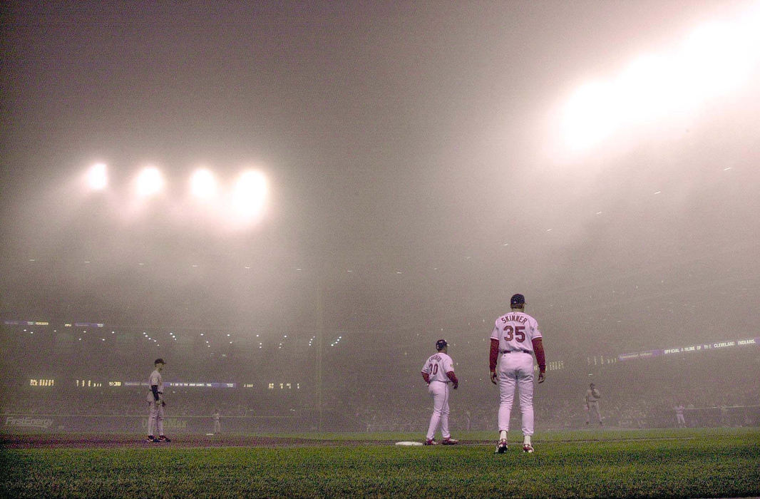 Second Place, Sports Picture Story - Chuck Crow / The Plain DealerSpring  baseball at Jacobs Field in Cleveland can witness huge weather changes, including this  huge fog that rolled in against the Baltimore Orioles.  Play was suspended after the 5th inning for a few minutes until the fog cleared, a first in Jacobs Field history. Play was resumed.  