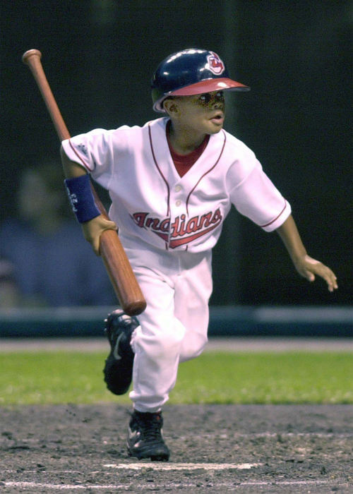 Second Place, Sports Picture Story - Chuck Crow / The Plain DealerGuest batboy Christopher Burks carries the bat of Omar Vizquel back to the dugout during a game at Jacobs Field in May.  He brought his dad, Ellis Burks, good luck as Burks had six rbi in the Tribe victory.  Christopher is 6 years old. 