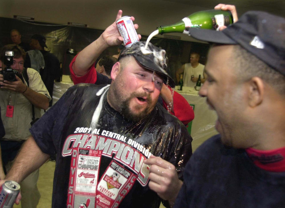 Second Place, Sports Picture Story - Chuck Crow / The Plain DealerCleveland Indians closer Bob Wickman gets a champagne and beer shower in the Indians locker room after winning the A.L. Central Division title.  On the right watching the celebration is Indians rookie C.C. Sabathia.  It was the 6th time in 7 years that they made the playoffs but it was the first time for Wickman to win a Divisional crown.  