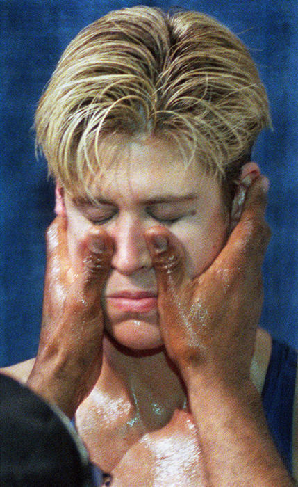 Third Place, Sports Picture Story - Gus Chan / The Plain DealerLorenzo Scott rubs vaseline on the face of Vonda Ward before her fight Friday, February 2, 2001, with Kisha Snow, of Brooklyn, NY.   