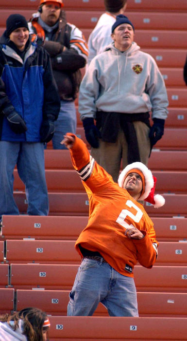 First Place, Sports Picture Story - Scott Heckel / The RepositoryA Browns fan in the Dawg Pound, wearing a Tim Couch jersey and a Santa hat, throws a beer botte towards the field after the game with the Jacksonville Jaguars was stopped with 48 seconds remaining after officials reversed an apparent first down catch.