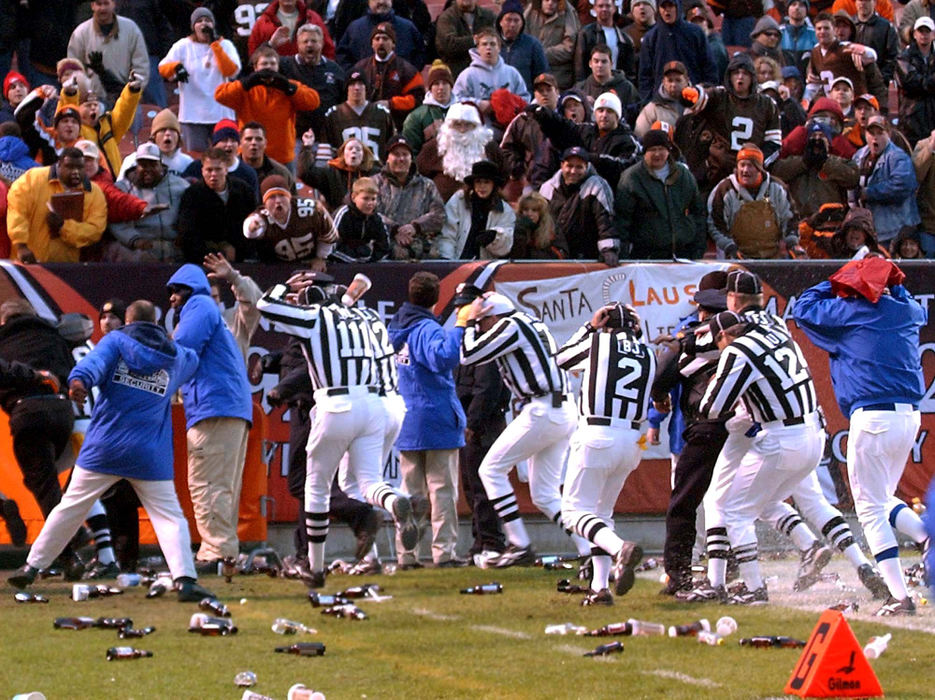 First Place, Sports Picture Story - Scott Heckel / The RepositoryGame officials cover their heads and leave the field at Cleveland Browns Stadium while fans pelted them with plastic bottles and cups. 