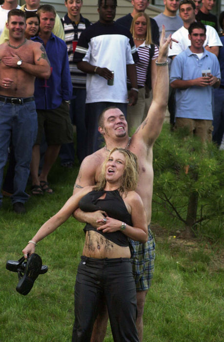 Second Place, Team Picture Story - Phil Masturzo / Akron Beacon Journal A man calls for encouragement from onlookers as he gets ready to toss a woman back into a pond at the off campus apartment complex.