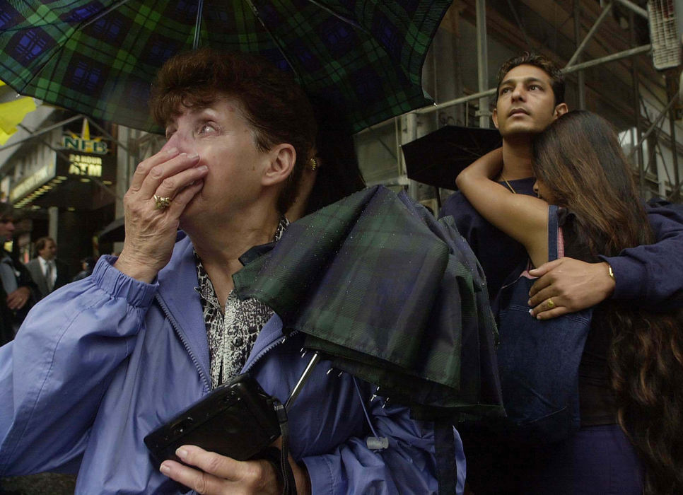 Award of Excellence, War on Terror - Karen Schiely / Akron Beacon JournalBridget Gillman, left, begins to cry as she sees the collapsed World Trade  Centers towers in Lower Manhattan for the first time since the attack. Behind Gillman, Gabriel Gomes, of New York  City, comforts his wife Teresa Gomes as they also see the site for the first time  since the attack. 