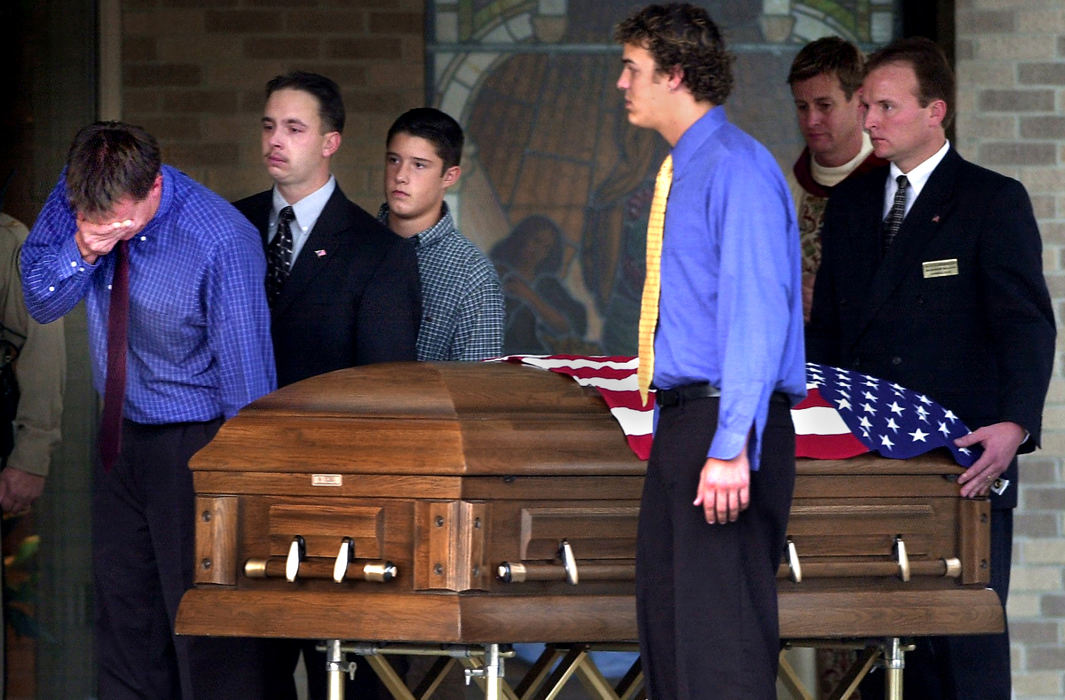 Award of Excellence, War on Terror - Craig Ruttle / Cincinnati EnquirerPallbearers made up of Brian William's cousins walk the flag-draped coffin of Brian Williams, 29, to a waiting hearse after a funeral at the St. Pius X church in Edgewood, Kentucky Sunday, October 21, 2001. Mr. Williams was killed as he worked at the Cantor Fitzgerald investment firm on the 104th floor of One World Trade Center in New York during a terrorist attack on the building Sept. 11, 2001. 