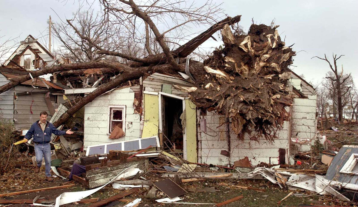 Second Place, News Picture Story - Allan Detrich / The BladeSteve Tooman of Columbia Gas company, signals he can't find the source of gas odors around this home. The home has a complete tree on the roof and is just south of the city park. Rescue workers were now allowed to enter the building.