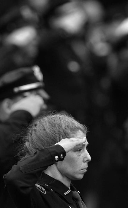 First Place, News Picture Story - Ed Suba, Jr. / Akron Beacon JournalA member of the police community fights with her emotions as she stands at attention during the playing of taps during a memorial service for slain Massillon police officer Eric Taylor at Mt. Peace Cemetery in Akron.